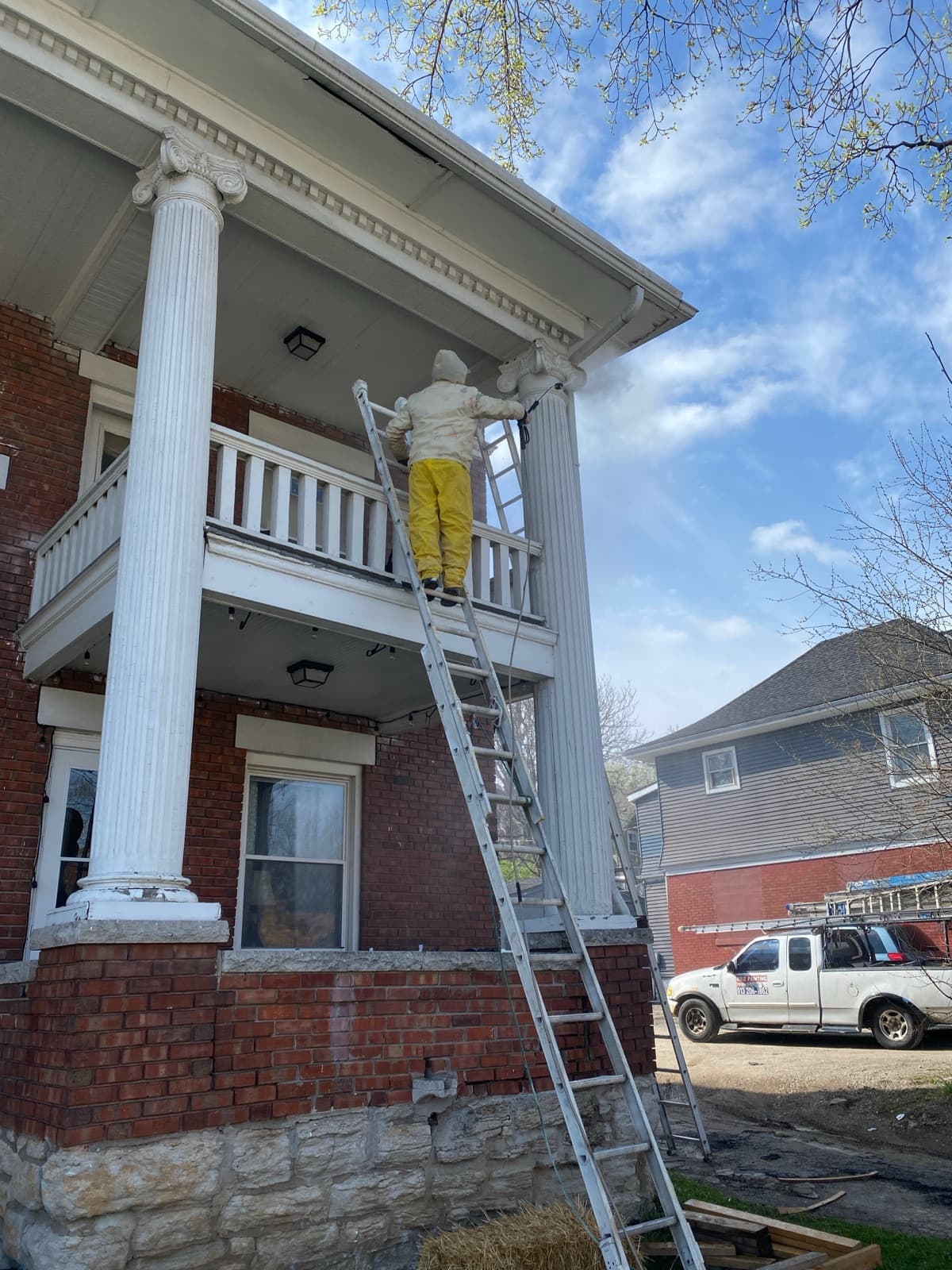 Ruiz Painting crew spraying the columns of a historic brick home