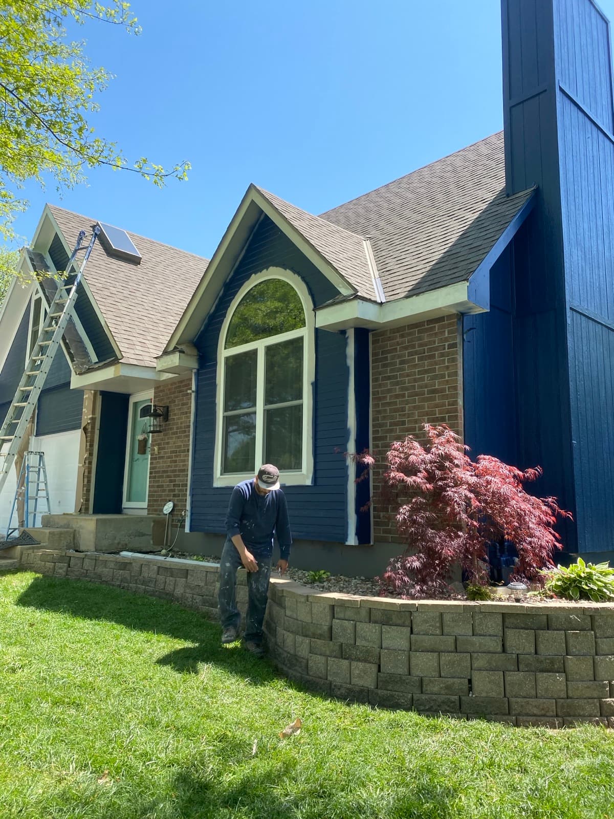 Ruiz Painting crew finishing a navy blue exterior repaint in Kansas City